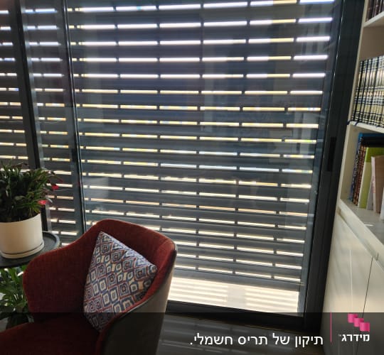 תריסים אופקיים אפורים על חלון זכוכית גדול